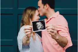 Parents holding the picture of their baby